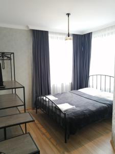 a bedroom with a bed and two large windows at Garemta in Stepantsminda