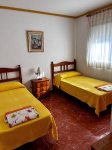duas camas num quarto com lençóis amarelos em Apartamentos Inter Gandia Playa em Gandia