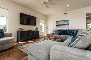 a living room with two couches and a flat screen tv at Coastal Charm, gulf front, new build in Dauphin Island