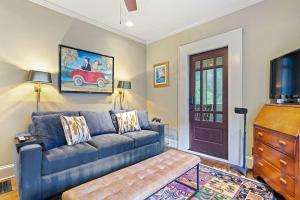 a living room with a blue couch and a tv at Piedmont Park Pool-Side Retreat in Atlanta