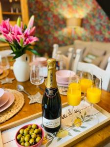 eine Flasche Champagner und Gläser Orangensaft auf dem Tisch in der Unterkunft Overleigh Cottage, with optional Hot Tub hire in Chester