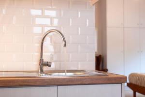 a kitchen counter with a sink in a kitchen at Serenity - Brand New Apt Near Athens Int Arpt in Spata +42 photos