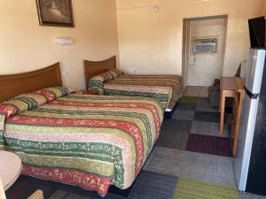 Habitación de hotel con 2 camas y TV en Relax Inn Goldthwaite, en Goldthwaite