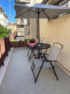 a table and chair with an umbrella on a patio at Cà di Buole A in Mestre