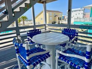 a table and four chairs on a deck with the beach at Beach Dream in Navarre