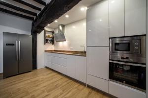 a kitchen with white cabinets and a stainless steel refrigerator at Casa rural Iturrikoa in Urritzola
