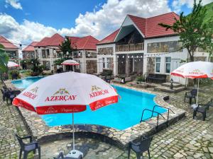 ein Resort mit einem Pool mit Sonnenschirm in der Unterkunft FGarden Hotel Sheki in Şəki