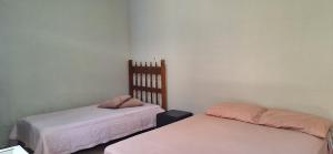 um quarto com duas camas com lençóis cor-de-rosa em Casa de Hospedagem Uberaba em Uberaba