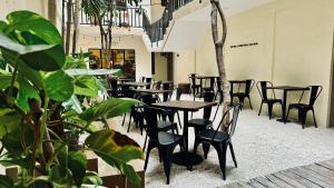 a row of tables and chairs in a room with plants at Hotel Noah Tulum in Tulum