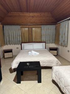 Hotel Marsil في Tepelenë: غرفة نوم بسرير كبير وطاولة