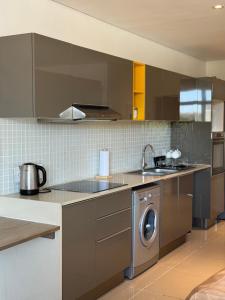 a kitchen with a sink and a washing machine at Cosy one bedroom apartment in Windhoek