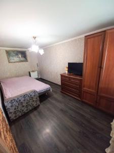 1 dormitorio con 1 cama, vestidor y TV en Котедж "Гірський Затишок", en Yaremche