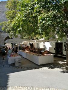 een openluchtmarkt met tafels en stoelen onder een boom bij La retapée in Quinson +20 foto's