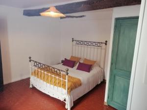 a bedroom with a bed and a green door at La retapée in Quinson