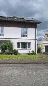 een wit huis aan de kant van een straat bij Dohlennest, helle moderne Wohnung für 4 Personen in Mülheim an der Ruhr