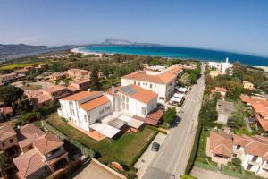 an aerial view of a town with houses and the ocean at HOTEL Al FARO , SPIAGGIA LA CINTA ,SAN TEODORO in San Teodoro