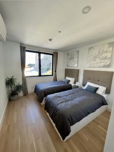 1 dormitorio con 2 camas y ventana en 2BR apartment with Spa & Gym en Gibraltar