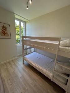 Dos literas en una habitación con ventana. en Le Domaine des Aguins, en Saujon