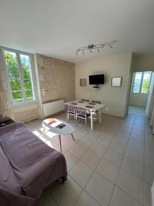ein Wohnzimmer mit einem Tisch und einem Sofa in der Unterkunft Le Domaine des Aguins in Saujon