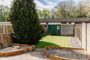 a garden with a tree and a fence at Hullidays 3 bed House Hull West Calvert in Hull