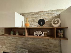 a shelf with a clock and vases on a brick wall at Onda di Porta a Mare in Livorno