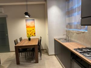 a kitchen with a table and a painting on the wall at Onda di Porta a Mare in Livorno +26 photos