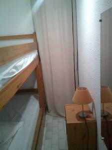 ein kleines Zimmer mit einem Etagenbett und einer Lampe in der Unterkunft Vittoria Immobilier 1-REGLEMENT SUR PLACE - Chèques Vacances acceptés in La Grande-Motte