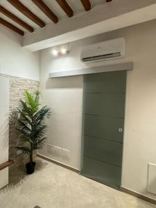 a green garage door in a room with a plant at Onda di Porta a Mare in Livorno