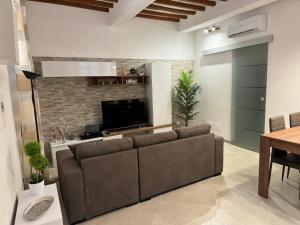 a living room with a couch and a flat screen tv at Onda di Porta a Mare in Livorno