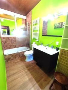 uma casa de banho verde com uma banheira, um WC e um lavatório. em Ducal 9 Manga Norte em La Manga del Mar Menor