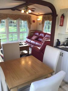 ein Wohnzimmer mit Tisch und Couch in der Unterkunft Pen llyn holiday cottages and caravan in Newborough