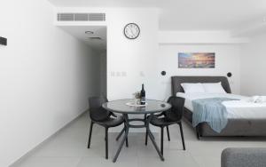 a bedroom with a bed and a table and chairs at סוויטות עם נוף וצמודות לים במתחם SeaSide היוקרתי עם בריכה - By SEAELO EILAT in Eilat +29 photos