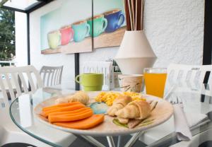 un plato de comida en una mesa de cristal con zumo de naranja en Almaviva Casa Hotel en Medellín