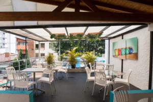 un restaurante con mesas y sillas y una gran ventana en Almaviva Casa Hotel en Medellín