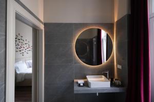 a bathroom with a sink and a mirror at Nine Athens Hotel in Athens