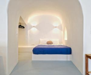 a small bedroom with a blue bed in a white room at Karpimo Scenery - Caldera Sunset View - Private Hot Tub - Firostefani in Firostefani