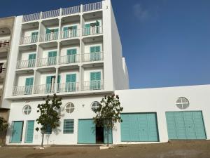 un immeuble avec volets bleus dans l'établissement Papaya Apartments Boa Vista, à Sal Rei