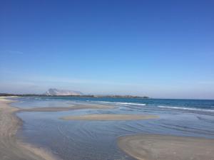 a beach with waves coming in from the ocean at HOTEL Al FARO , SPIAGGIA LA CINTA ,SAN TEODORO in San Teodoro