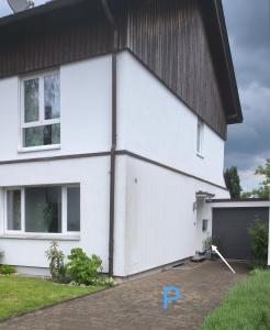 una casa blanca con techo negro en Dohlennest, helle moderne Wohnung für 4 Personen en Mülheim an der Ruhr