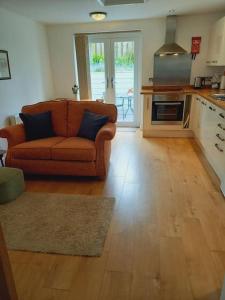a living room with a couch and a kitchen at Rose's Cottage in Gorran Haven