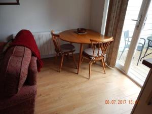 a living room with a table and chairs and a couch at Rose's Cottage in Gorran Haven +1 photo