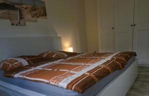 un letto con una coperta marrone e bianca. di Ferienhaus Strandmuschel am Ostseestrand Zierow a Zierow