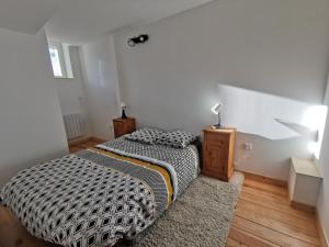 a bedroom with a bed with a black and white comforter at Le gîte de Melly in Bélesta