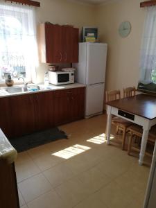 a kitchen with a table and a white refrigerator at Pokoje Augustowskie in Augustów