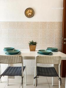 Una mesa con dos sillas y platos verdes encima. en Sea Haven Apartment #Propertly, en Nea Kalikratia