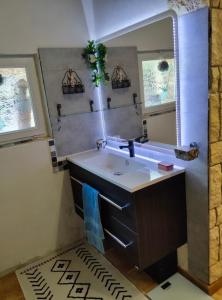 y baño con lavabo y espejo. en Chambre L'Orchidée en Vallon-Pont-dʼArc