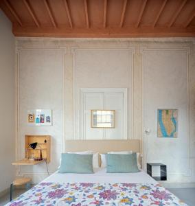 a bedroom with a bed with blue pillows at Hotel Hevresac Singular & Small in Mahón