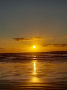 einen Sonnenuntergang am Strand mit Sonnenuntergang in der Unterkunft Casa em Unamar, Cabo Frio - com piscina privativa in Cabo Frio