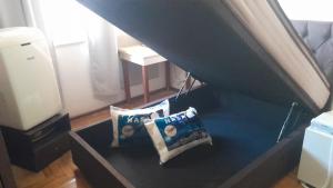 2 almohadas sentadas en una mesa bajo una cama en Apartamento Tubal, en Uberlândia