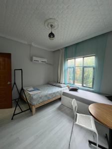a bedroom with a bed and a table and a window at Erkal Pension in Antalya